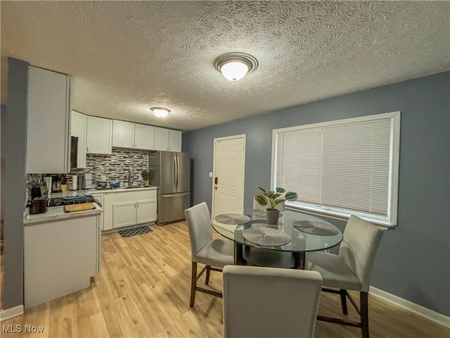 dining area featuring a textured ceiling and light hardwood / wood-style floors