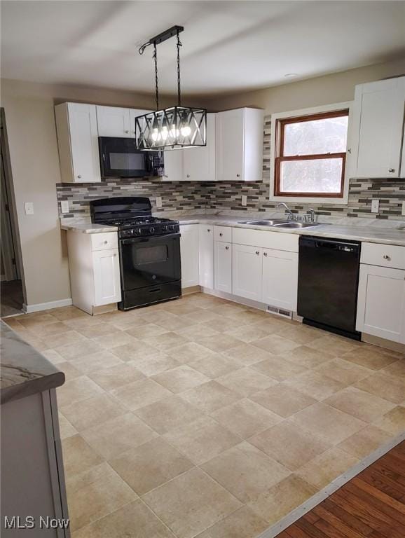 kitchen featuring pendant lighting, sink, track lighting, black appliances, and white cabinets