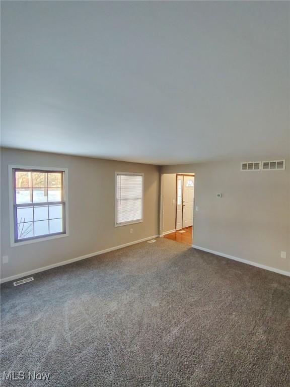 carpeted spare room featuring plenty of natural light