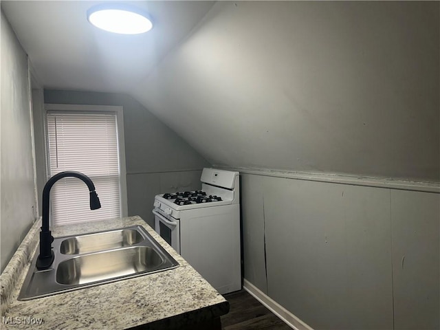 kitchen with vaulted ceiling, white range with gas cooktop, dark hardwood / wood-style flooring, and sink