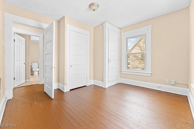 unfurnished bedroom with wood-type flooring and a closet