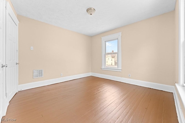 empty room with hardwood / wood-style floors