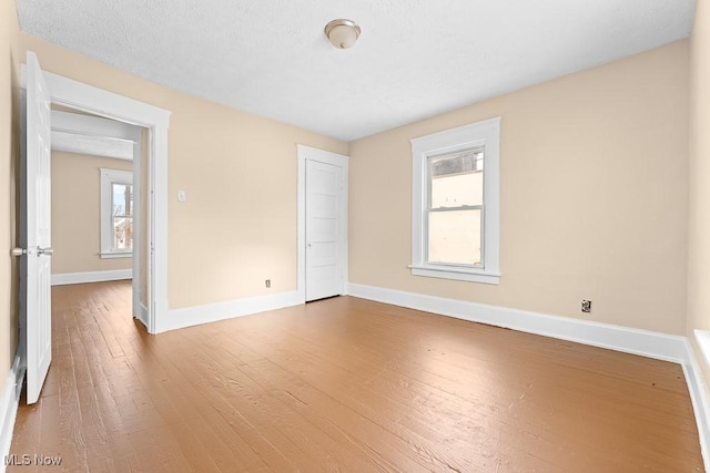 spare room featuring hardwood / wood-style flooring and a healthy amount of sunlight