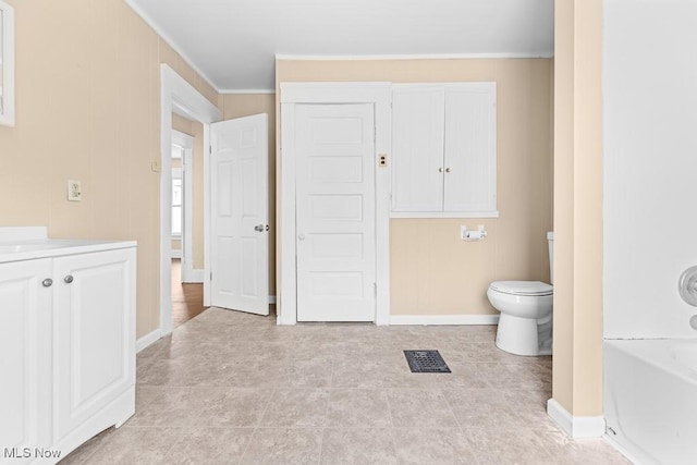 bathroom featuring vanity, ornamental molding, and toilet