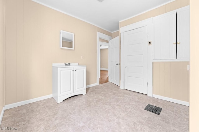 unfurnished bedroom featuring ornamental molding and sink