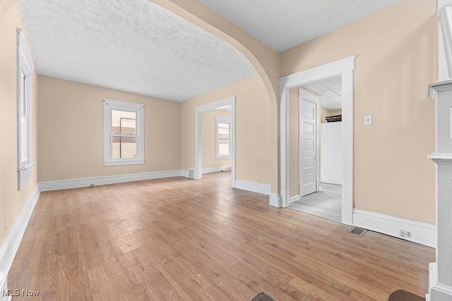 unfurnished living room featuring a textured ceiling and light wood-type flooring