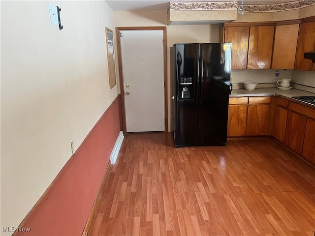 kitchen with electric cooktop, black fridge with ice dispenser, and light hardwood / wood-style flooring