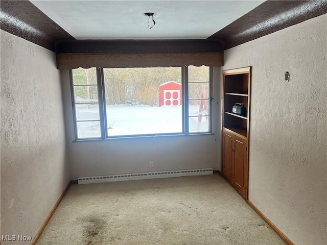 carpeted spare room with baseboard heating