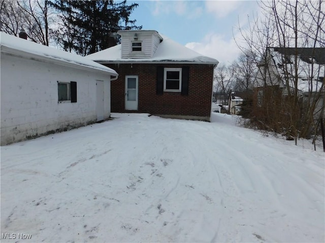 view of snow covered rear of property