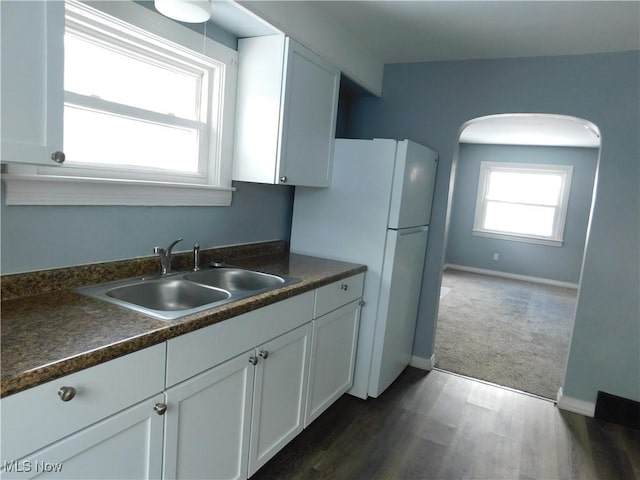 kitchen featuring sink, dark carpet, white cabinets, and white fridge