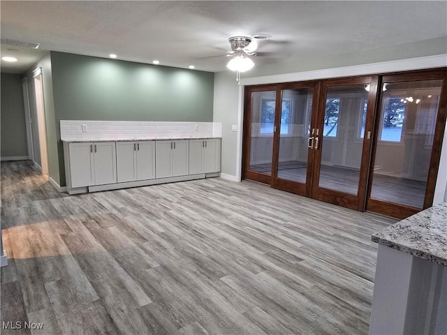 interior space with ceiling fan, light hardwood / wood-style floors, and french doors