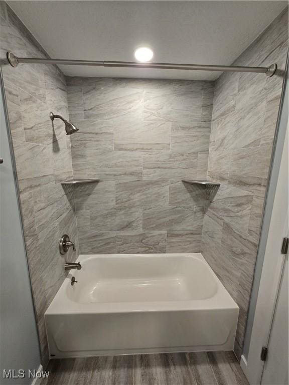 bathroom featuring wood-type flooring and tiled shower / bath combo