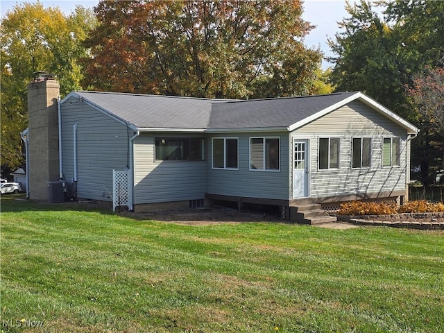 ranch-style house featuring a front lawn and central air condition unit