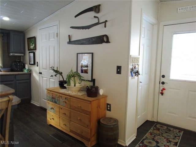 interior space featuring a healthy amount of sunlight, dark hardwood / wood-style floors, and crown molding