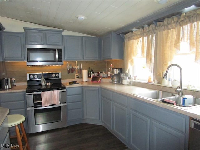 kitchen with vaulted ceiling, sink, stainless steel appliances, dark wood-type flooring, and wooden ceiling