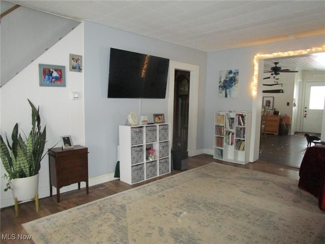 living room featuring ceiling fan and dark hardwood / wood-style flooring