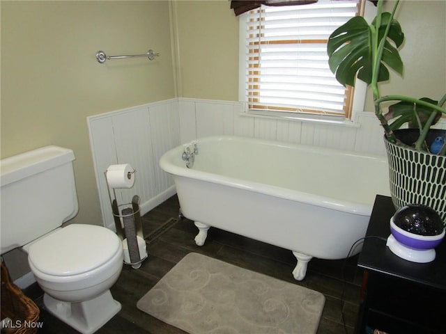 bathroom featuring a tub to relax in and toilet