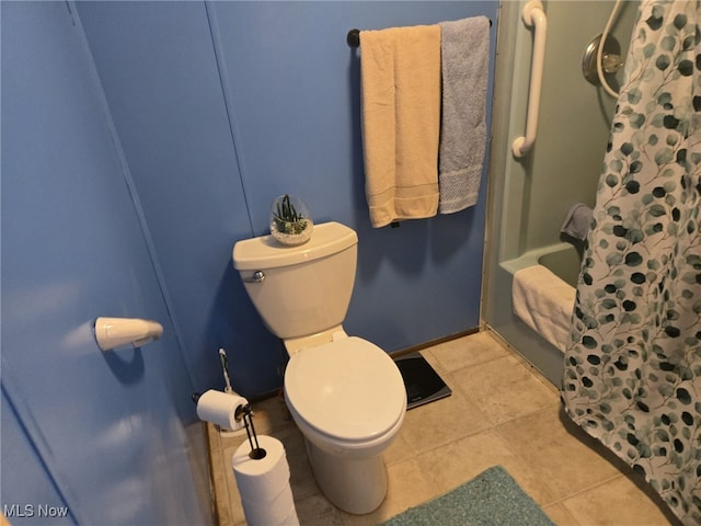 bathroom featuring tile patterned flooring, a shower with curtain, and toilet