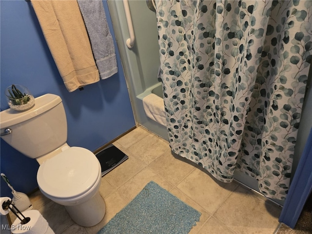 bathroom featuring a shower with curtain, toilet, and tile patterned flooring