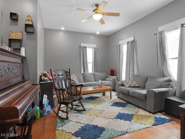 living room featuring hardwood / wood-style flooring, ceiling fan, a healthy amount of sunlight, and a textured ceiling