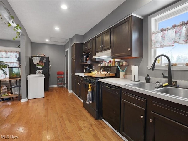 kitchen featuring sink, dark brown cabinets, black appliances, and light wood-type flooring