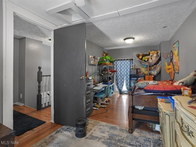 bedroom with a textured ceiling and light wood-type flooring