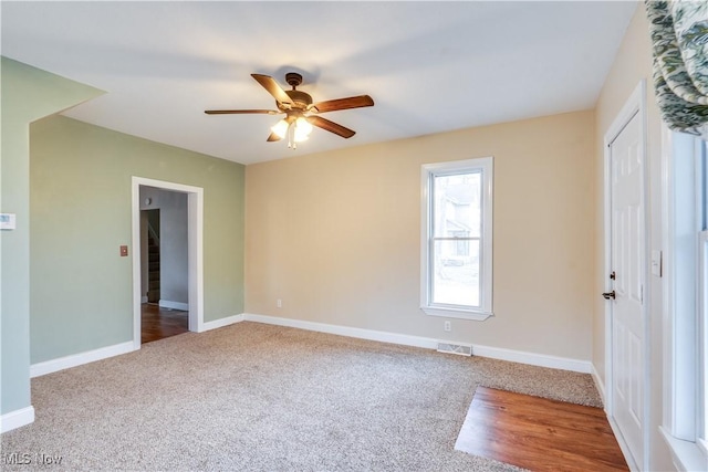 carpeted spare room with ceiling fan