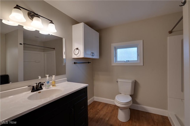 bathroom with walk in shower, vanity, toilet, and hardwood / wood-style floors