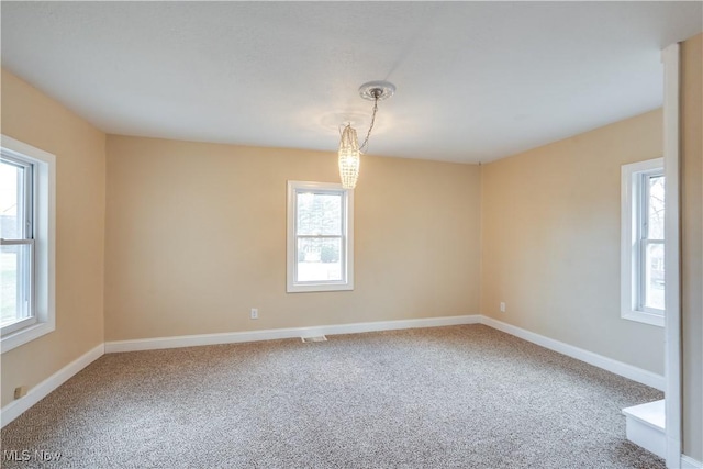 empty room with plenty of natural light and carpet flooring