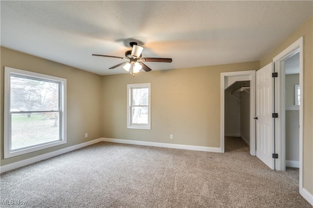 empty room with ceiling fan and light carpet