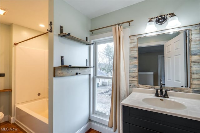 full bathroom featuring hardwood / wood-style flooring, vanity, shower / tub combo with curtain, and toilet