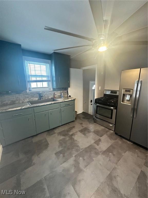 kitchen with appliances with stainless steel finishes, sink, and decorative backsplash