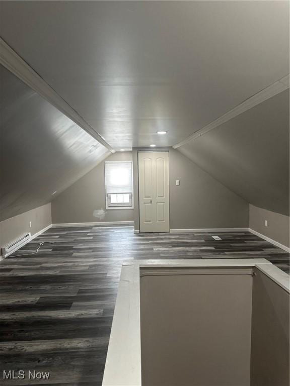 bonus room featuring lofted ceiling, a baseboard heating unit, and dark wood-type flooring