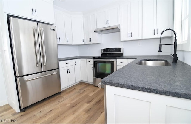 kitchen with stainless steel appliances, white cabinetry, sink, and light hardwood / wood-style floors