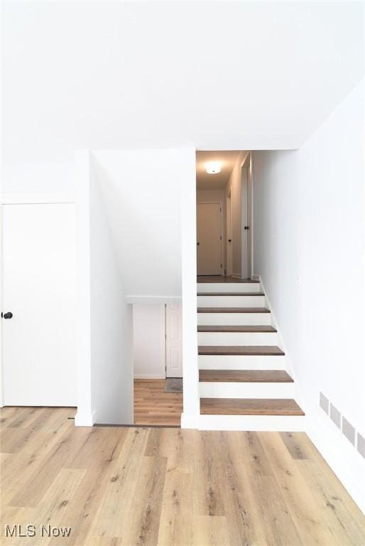 stairway with hardwood / wood-style floors