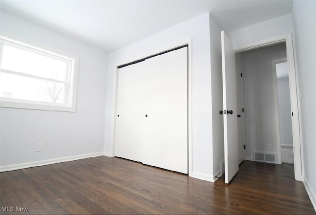 unfurnished bedroom with dark hardwood / wood-style flooring