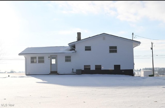 view of snow covered rear of property