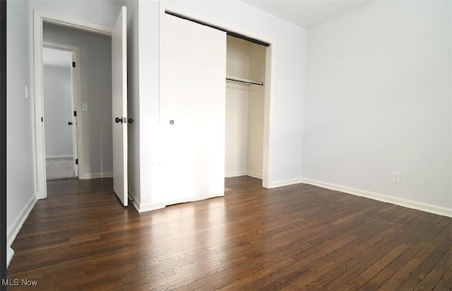 unfurnished bedroom featuring dark hardwood / wood-style floors and a closet