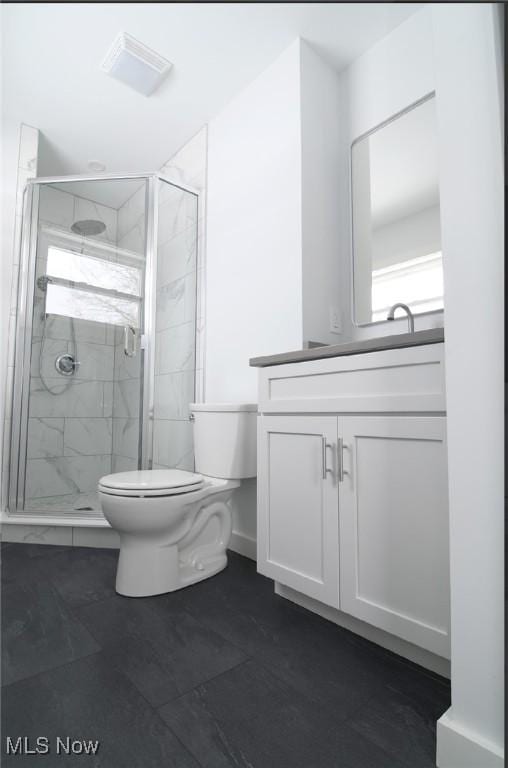 bathroom with vanity, toilet, and an enclosed shower