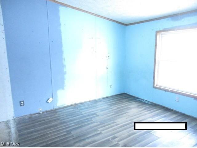 empty room with crown molding and hardwood / wood-style floors