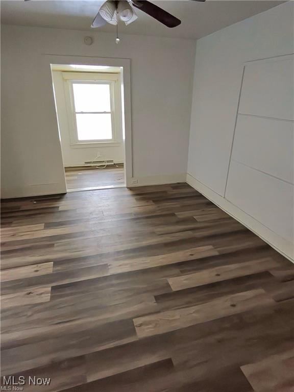 empty room with ceiling fan and dark hardwood / wood-style floors