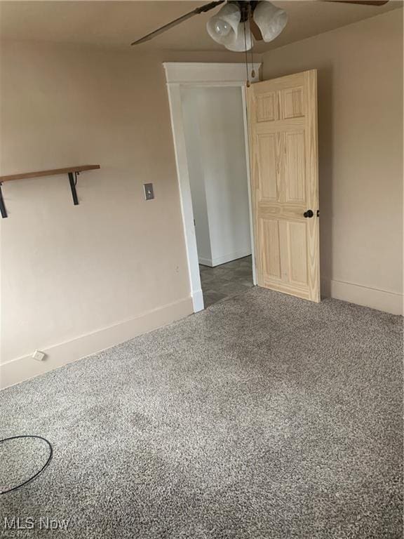 carpeted spare room featuring ceiling fan