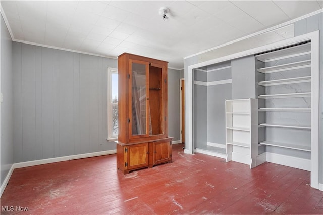 unfurnished living room with ornamental molding, wood-type flooring, and wood walls