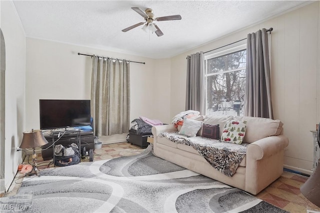 living room featuring ceiling fan and a textured ceiling