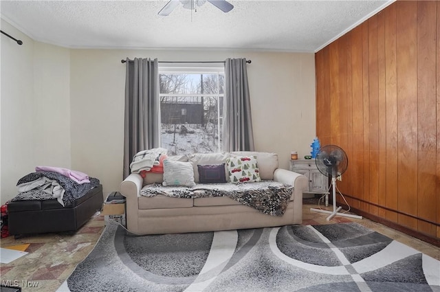 interior space featuring ceiling fan, a textured ceiling, and wood walls