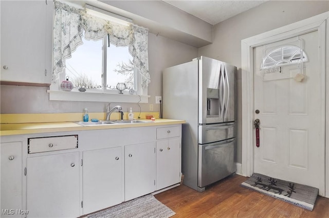 kitchen featuring white cabinets, sink, stainless steel fridge, and dark hardwood / wood-style floors