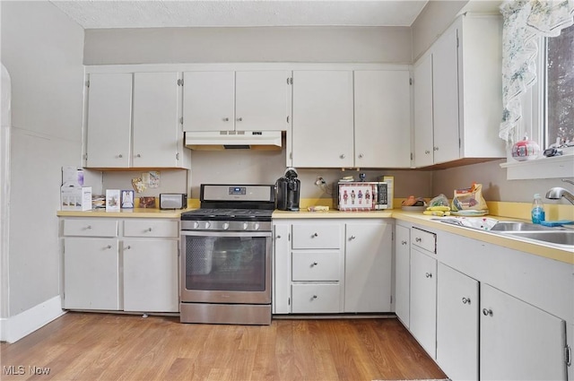 kitchen featuring light wood-type flooring, white cabinets, sink, and stainless steel gas stove