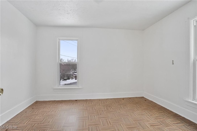 empty room featuring a textured ceiling and light parquet floors