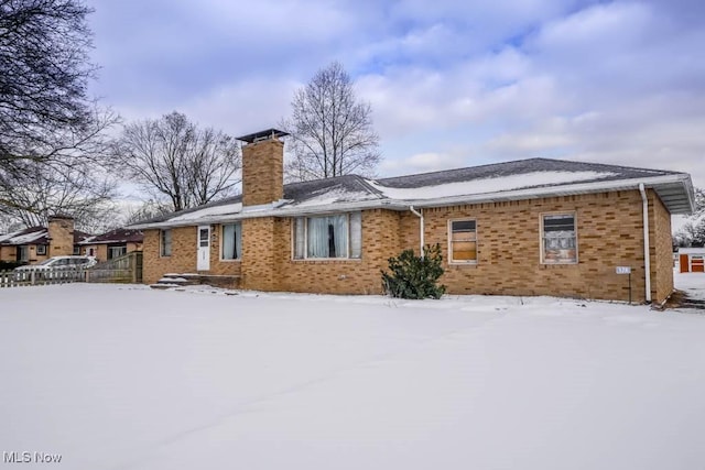 view of snow covered back of property