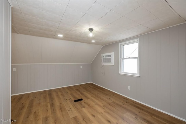 additional living space featuring hardwood / wood-style flooring and vaulted ceiling